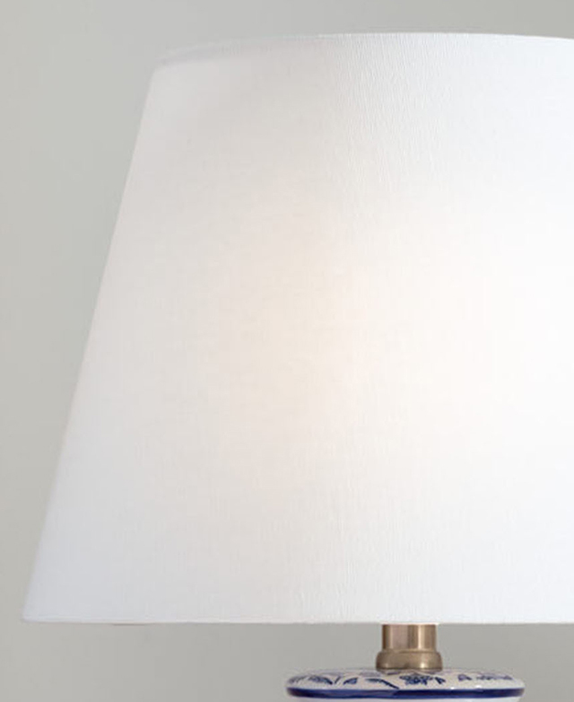 The white fabric empire shade is illuminated by the hidden bulb. The white fabric empire shade is illuminated by the hidden bulb.