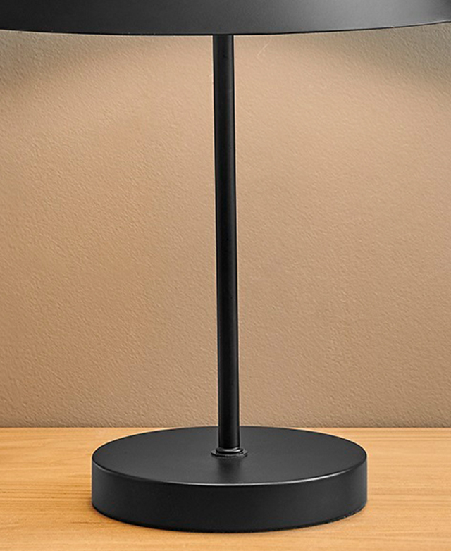 The black steel lamp has a very slender stand and simple, round base.