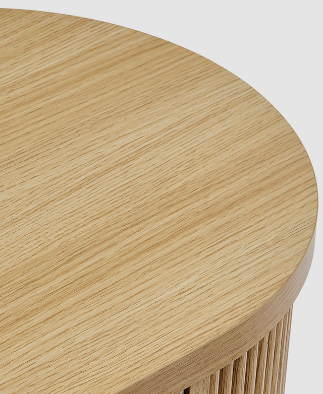 The rounded end of the entertainment unit is captured from a close bird's eye view, showing the laminate's wood grain effect.