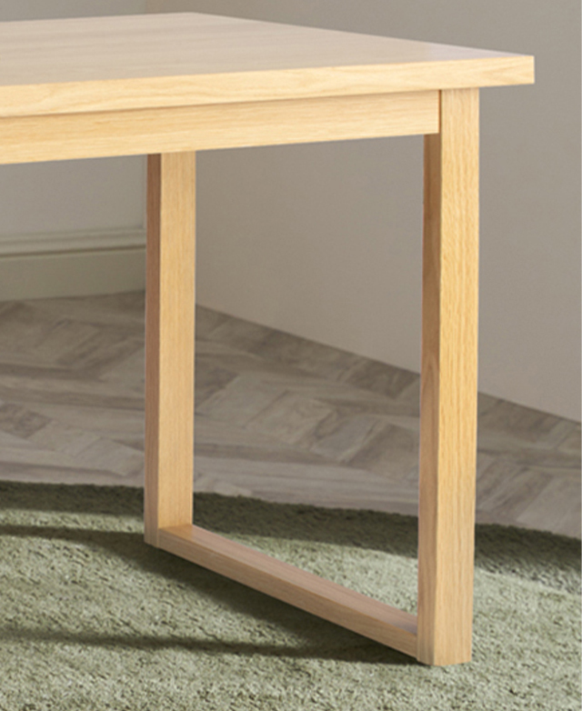 The open design of the ski-leg desk shows that airy look of the furniture. The ski leg is on a green rug.
