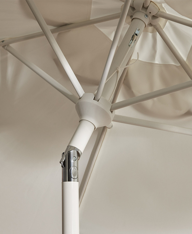 The cream-colour stand and spokes on the inner side of the umbrella support the canopy.