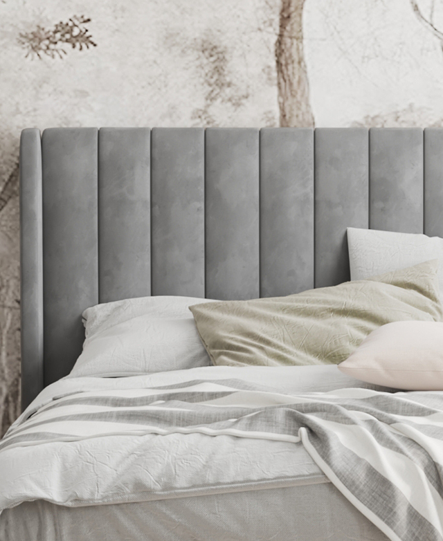 The focus is the bedhead, which is adorned with neat channel stitching. Soft-toned bedding layers dress the bed.