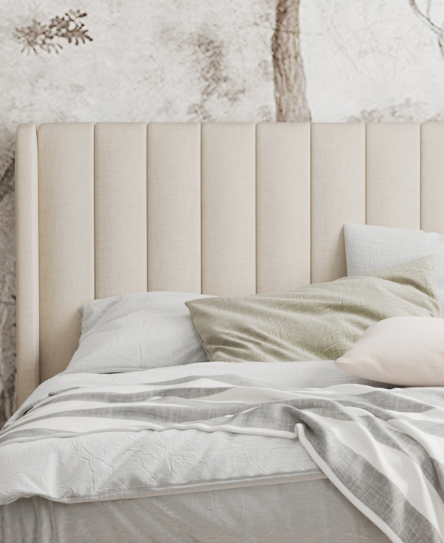 The focus is the bedhead, which is adorned with neat channel tufting. Soft-toned bedding layers dress the bed.