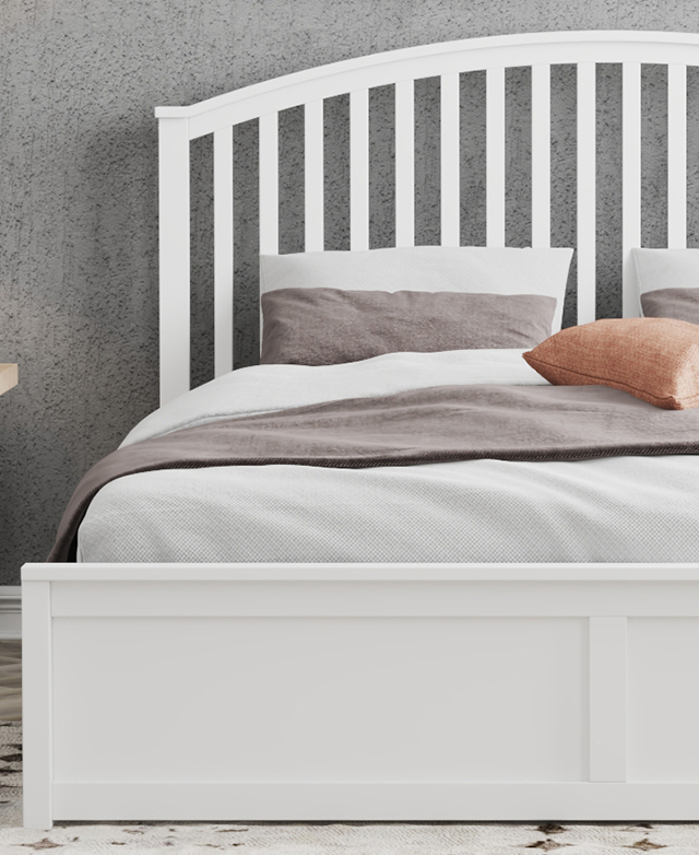 The arched white wood bedhead is flush against a grey wall, and the bed is dressed with cream and grey bedding. The arched white wood bedhead is flush against a grey wall, and the bed is dressed with cream and grey bedding.