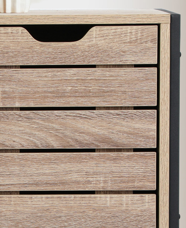 Close-up of the top of the storage cabinet highlights the slatting on a cupboard door, and its recessed handle.