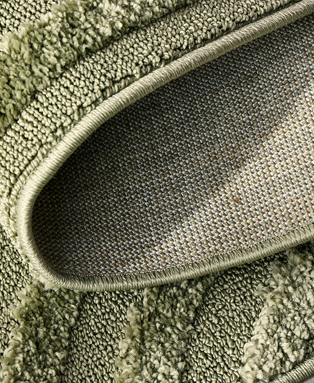 The pistachio rug is folded back on itself.