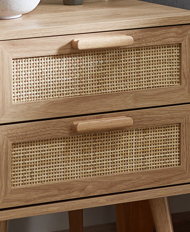 Focus is on the front of the bedside table, where woven rattan drawer panels and thick bar handles are emphasised. Focus is on the front of the bedside table, where woven rattan drawer panels and thick bar handles are emphasised.