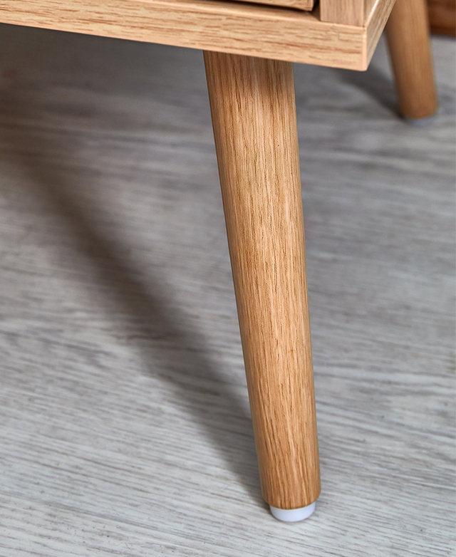 One of the oak wood legs is zoomed in on to show its smooth, modern tapered shape and natural grains. One of the oak wood legs is zoomed in on to show its smooth, modern tapered shape and natural grains.
