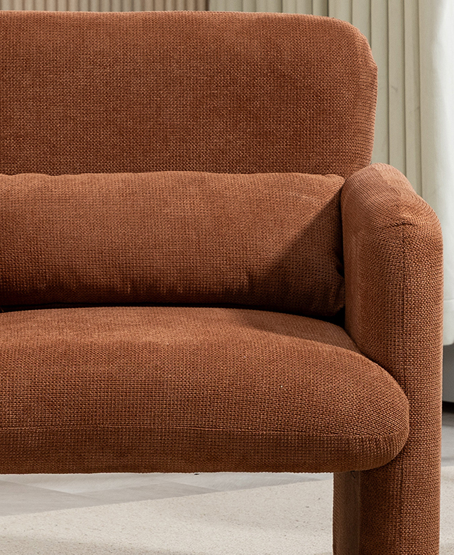 A front-facing shot of the rust orange armchair highlights its clean angles, rounded corners, and the seat's floating effect. A front-facing shot of the rust orange armchair highlights its clean angles, rounded corners, and the seat's floating effect.