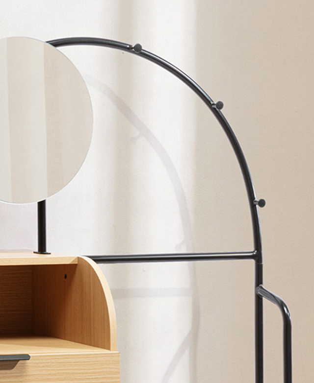The top portion of the black, arched powder-coated iron frame is throwing shadows onto the cream wall behind. The top portion of the black, arched powder-coated iron frame is throwing shadows onto the cream wall behind.