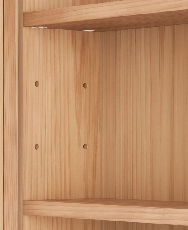 The inner wall of the cabinet is revealed to display pre-drilled holes that allow for shelf adjustability.