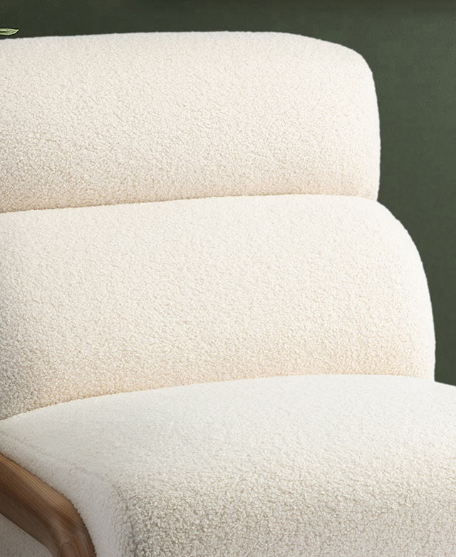 Plush, cream teddy fabric of the armchair is emphasised by the backrest's horizontal panel stitching. Plush, cream teddy fabric of the armchair is emphasised by the backrest's horizontal panel stitching.