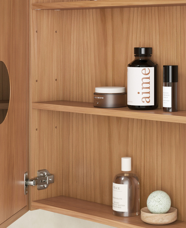 The cabinet door is open to reveal a magnifying mirror and two shelves that are filled with grooming products. The cabinet door is open to reveal a magnifying mirror and two shelves that are filled with grooming products.