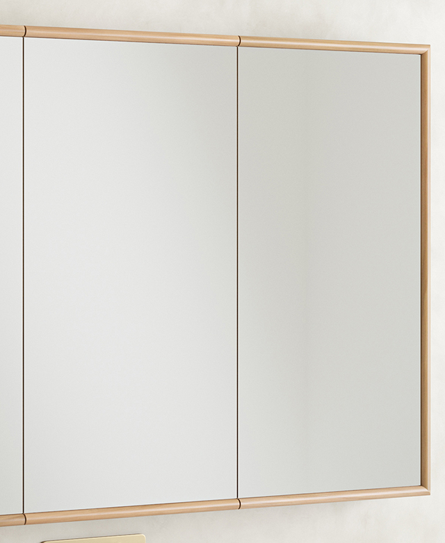 A large, rectangular, mirrored cabinet is positioned on a concrete-look wall. A large, rectangular, mirrored cabinet is positioned on a concrete-look wall.