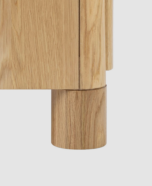 Close up of a thick, cylindrical oak wood leg highlights the natural grains and warm, tonal colours.
