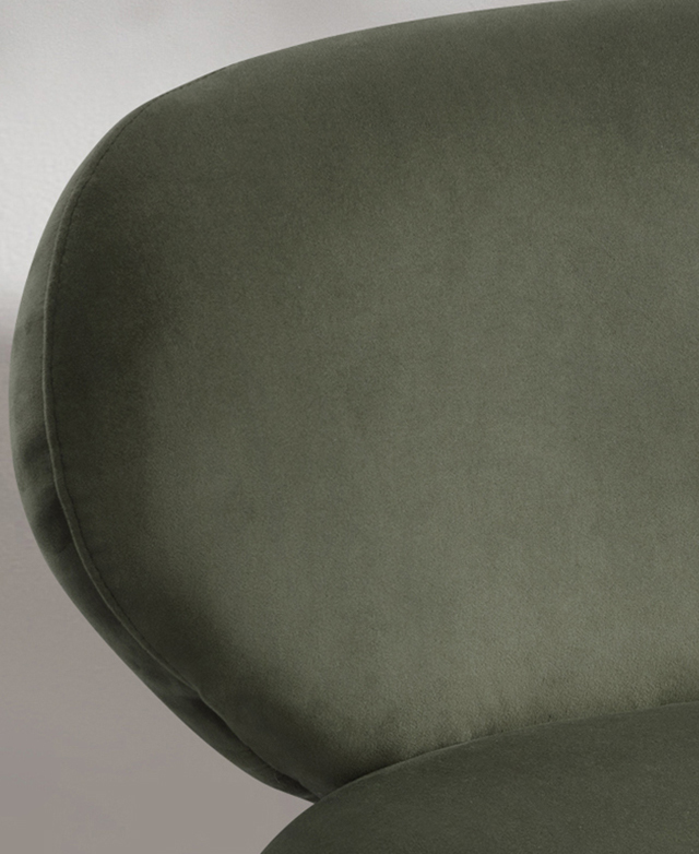 Cropped view zooms in on the silky-smooth texture of the green velvet upholstery.