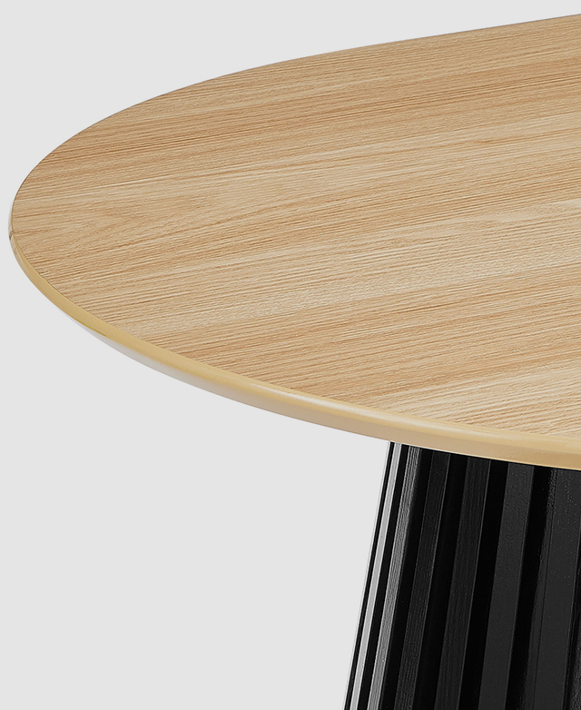 One end of the oak and black dining table is zoomed in on to highlight the smooth surfaces and the bevelled edge. One end of the oak and black dining table is zoomed in on to highlight the smooth surfaces and the bevelled edge.