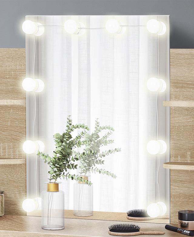 The dressing table's mirror is framed with illuminated LEDs, and beauty items and a bouquet are on the table's surface.