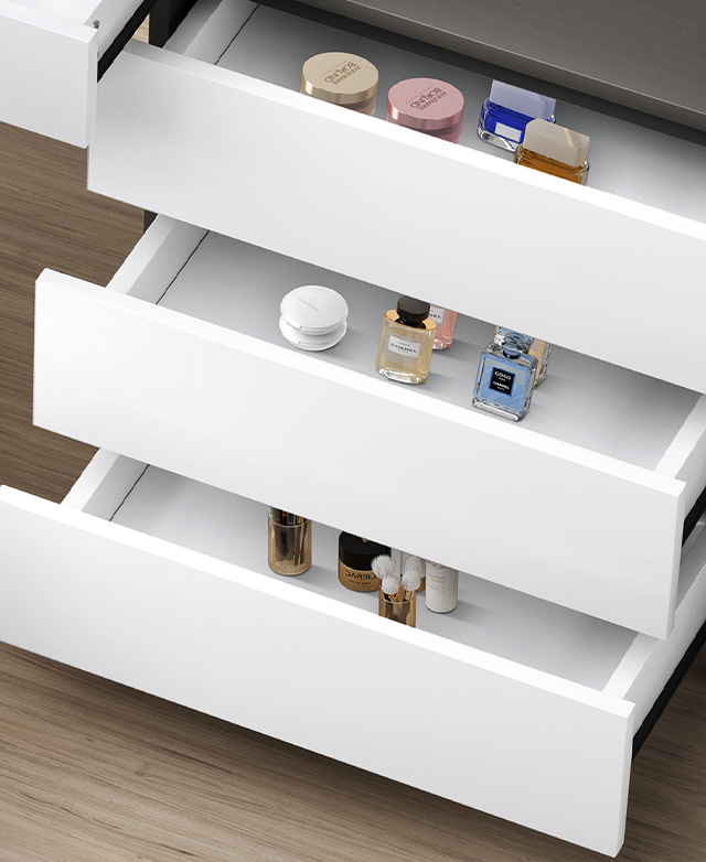 Three white drawers are open and have various beauty items inside.