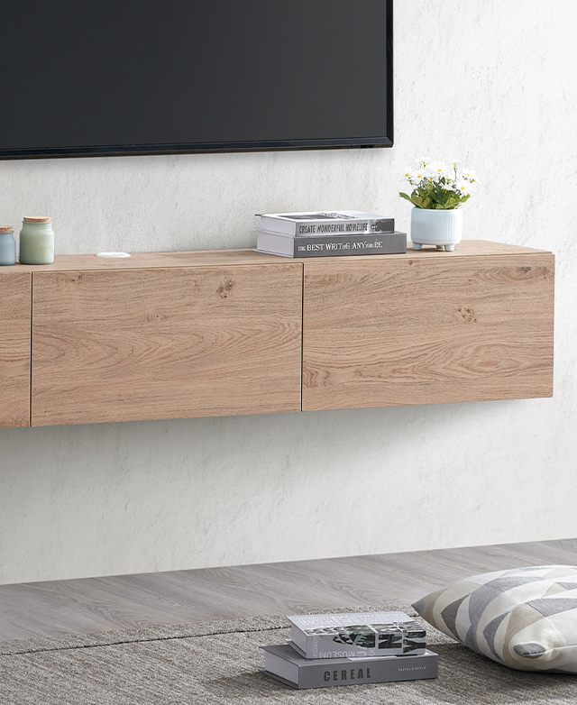 A floating TV unit is fixed to a white wall over a light grey floor; a TV is positioned over the top against the wall.