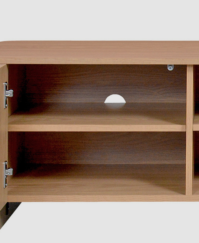 A cupboard door of the TV cabinet is open to reveal storage space and a cable management hole. A cupboard door of the TV cabinet is open to reveal storage space and a cable management hole.