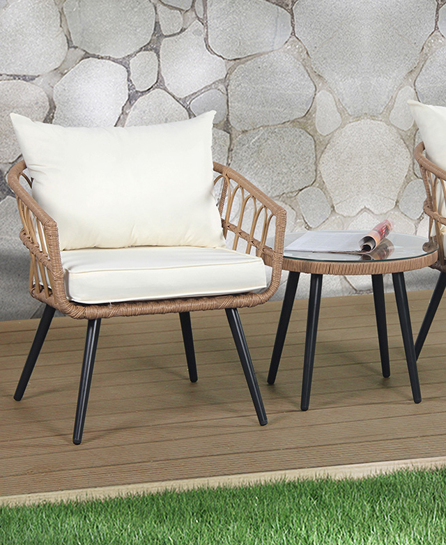 A front-facing cushioned amrchair and side table is positioned on timber decking next to a patch of grass. A front-facing cushioned amrchair and side table is positioned on timber decking next to a patch of grass.