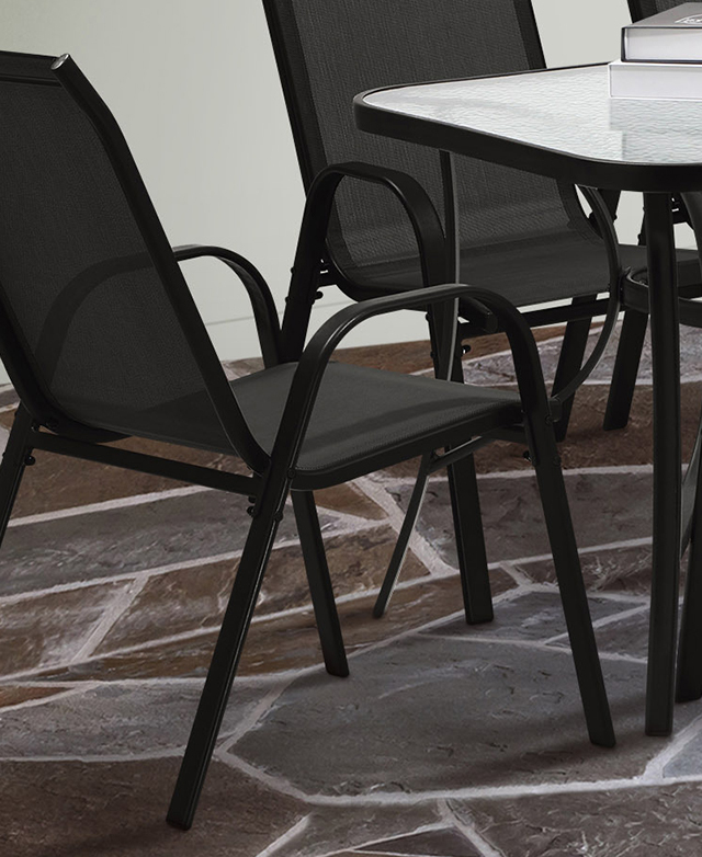 A rounded, U-shaped black metal armrest-cum-leg structure is in focus, and positioned next to a dining table.