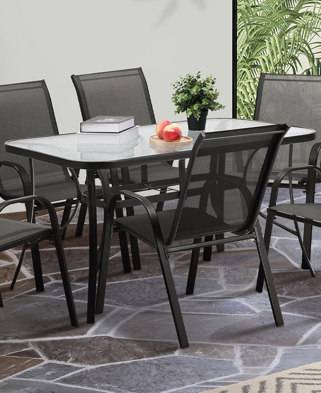 The full rectangular glass-top table is shown with coordinating black-framed armchairs around it.