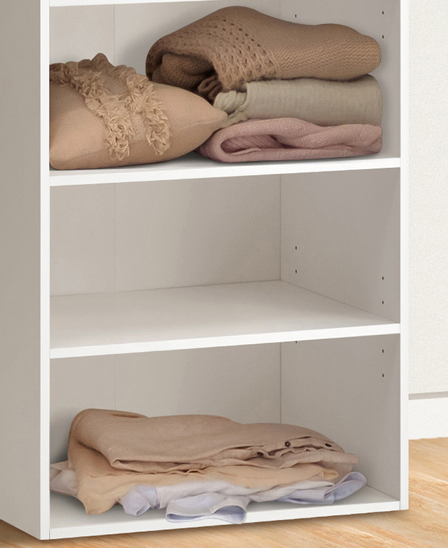 Cropped view shows the slender frame and shelves, with textiles folded on two out of three shelves. Cropped view shows the slender frame and shelves, with textiles folded on two out of three shelves.