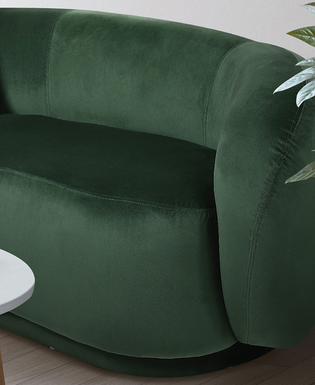The plush but firm seat and low backrest are upholstered in a rich green velvet fabric.