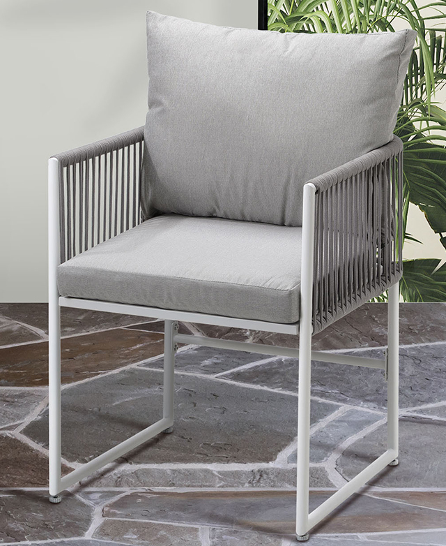 A white and grey armchair is shown on irregular grey-toned outdoor tiles.