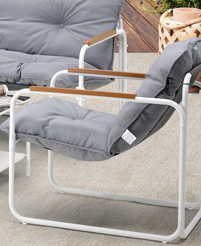 A side view of the white armchair highlights the floating effect of the sling seat and the contemporary, simple frame.