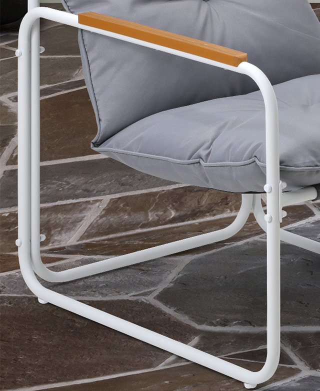 A cropped three-quarter angle of the armchair displays the slender, open design of the white metal frame.