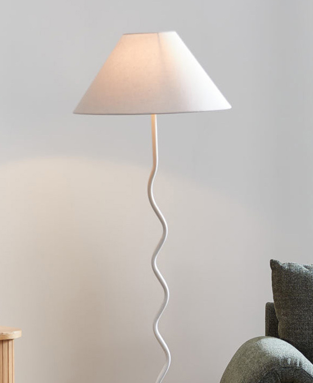 The white floor lamp is turned on, with the empire shade keeping the light soft. The white floor lamp is turned on, with the empire shade keeping the light soft.