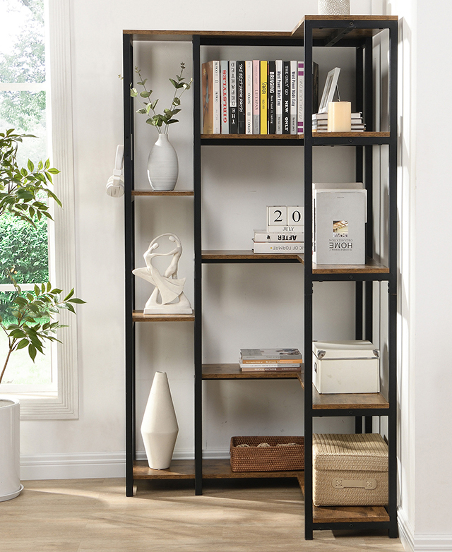The corner of a white, light room is furnished with the corner bookshelf, which is filled with decor and books.