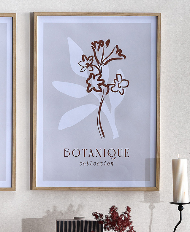 A burgundy floral line painting on a taupe background is in a 'natural' frame and hung on a white wall.