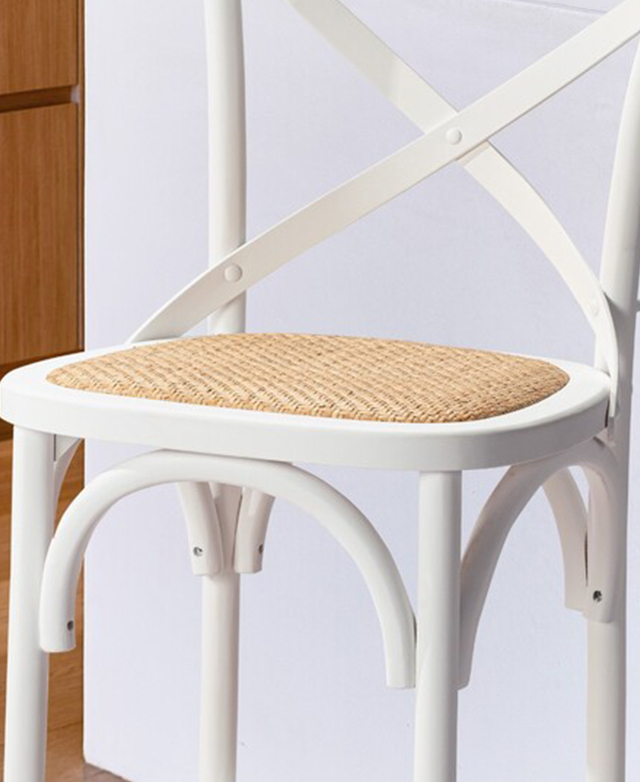 A woven rattan seat is framed by white, rounded birch wood edges.