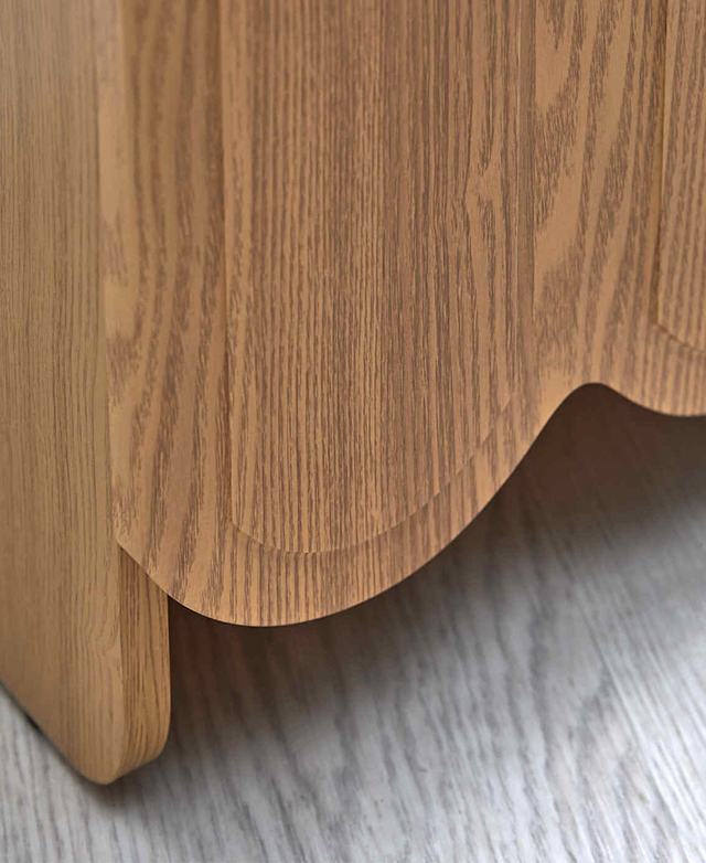 Part of the bottom edge of the side table is in focus to highlight the scalloping and the veining detail.