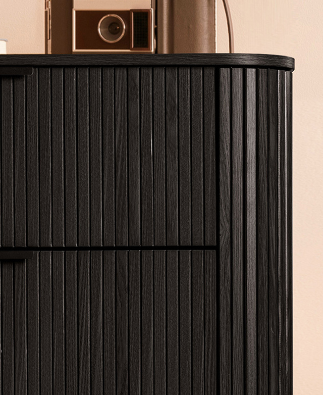 The cropped chest of drawers highlights the roundedness and the textured fluting around the sides and on the front.