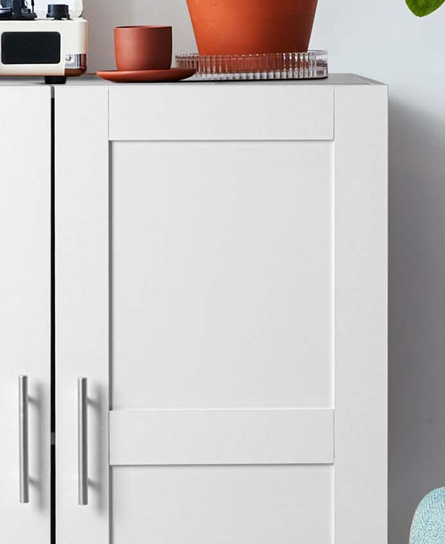 The cropped view highlights the panelled, shaker-style door fronts; decor is displayed on top.