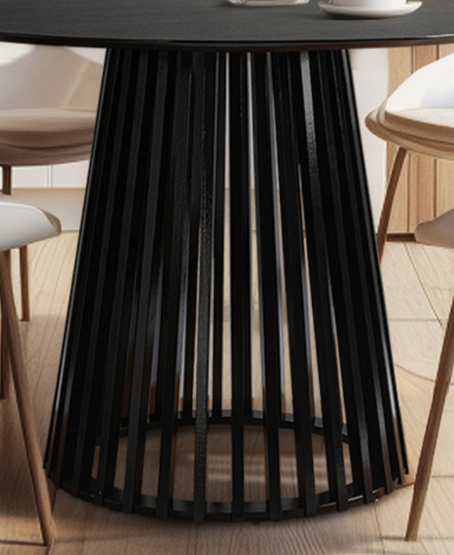 The slatted, tapering pedestal base of the black dining table has chairs around it. The slatted, tapering pedestal base of the black dining table has chairs around it.