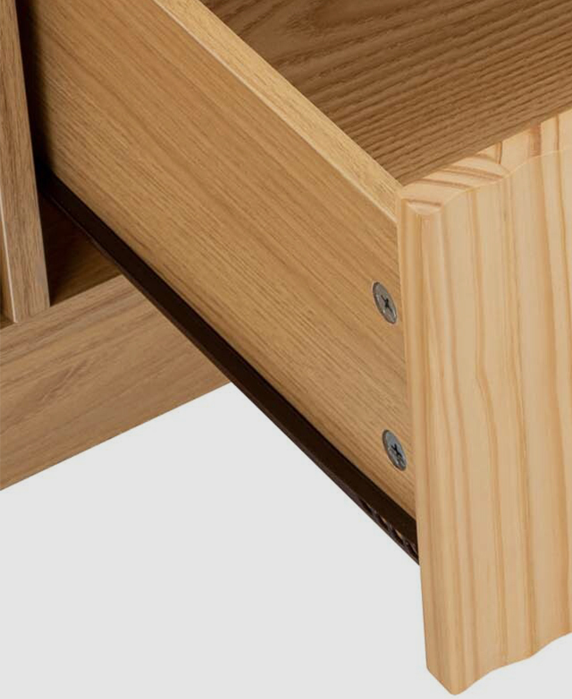 One drawer of the light timber TV unit is shown open, the black metal runner is in the frame. One drawer of the light timber TV unit is shown open, the black metal runner is in the frame.