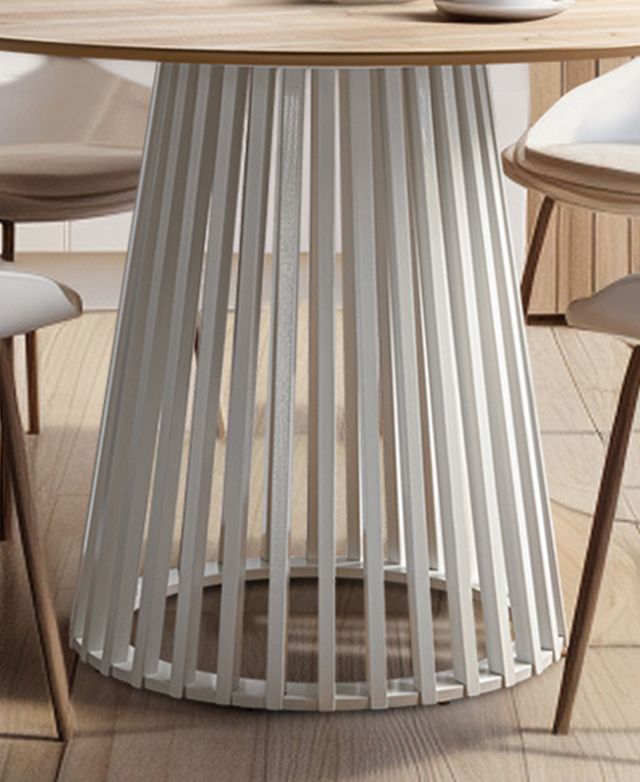 The slatted, tapering pedestal base of the white and natural dining table has chairs around it. The slatted, tapering pedestal base of the white and natural dining table has chairs around it.