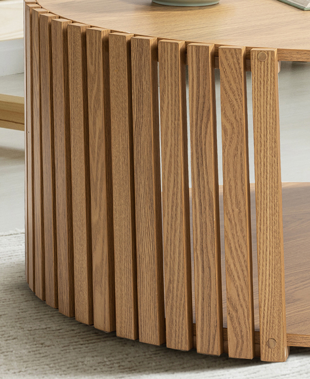 The rounded shape of the coffee table is framed by the vertical slats, where the wood-grain-effect is in focus.