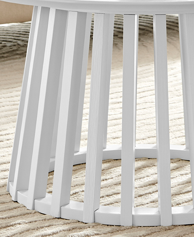 The white, vertical slats and negative space between them demonstrate the coffee table's airy design. The white, vertical slats and negative space between them demonstrate the coffee table's airy design.