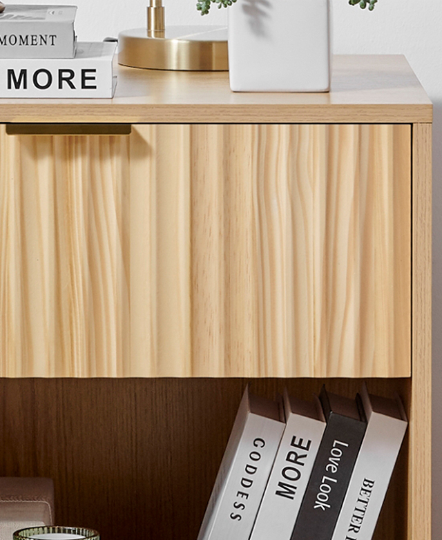 Cropped view of the side table highlights the textured fluting; decorative items are on top, and books lean on the shelf