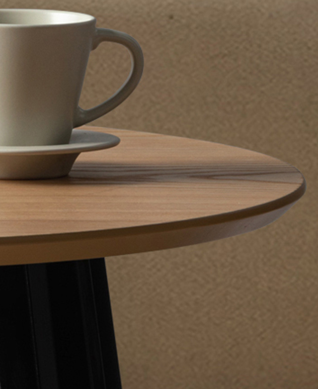 A rounded, bevelled table's edge and natural wood grains show texture and a smart finish.