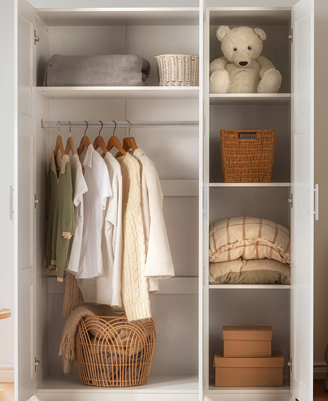 Doors are open to reveal generous storage space that contains hung and folded clothing, plus baskets, toys, and bedding. Doors are open to reveal generous storage space that contains hung and folded clothing, plus baskets, toys, and bedding.