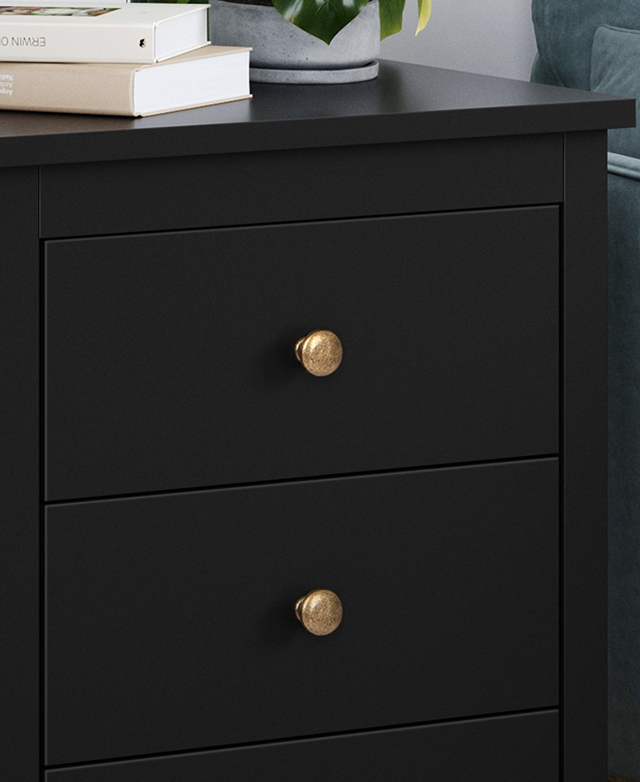 Smooth black melamine surfaces of the side table and the golden knobs on the drawers show its polished finish. Smooth black melamine surfaces of the side table and the golden knobs on the drawers show its polished finish.