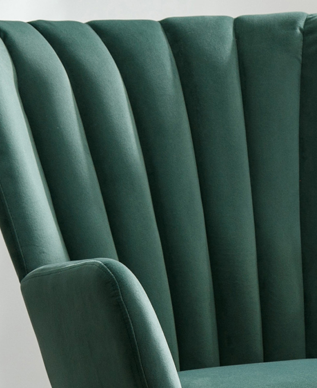 Close up view of the green armchair underlines the silky-soft texture of the panelled velvet backrest. Close up view of the green armchair underlines the silky-soft texture of the panelled velvet backrest.